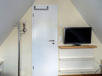 Ein Schlafzimmer mit LCD-TV im ausgebauten Spitzboden im  Ferienhaus Amy